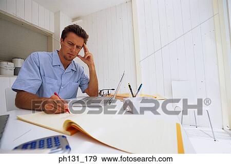 Caucasian man working on a desk View Large Photo Image Stock Photo - Caucasian man working on a desk. Fotosearch