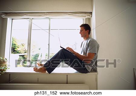 Caucasian man working on a laptop View Large Photo Image Stock Image - Caucasian man working on a laptop. Fotosearch