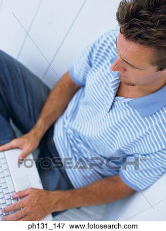 Caucasian man working on a laptop View Large Photo Image Stock Photo - Caucasian man working on a laptop. Fotosearch