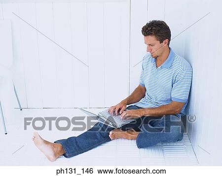 Caucasian man working on a laptop View Large Photo Image Stock Photograph - Caucasian man working on a laptop. Fotosearch