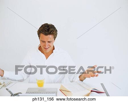 Stock Photograph - Caucasian sitting on a desk. Fotosearch