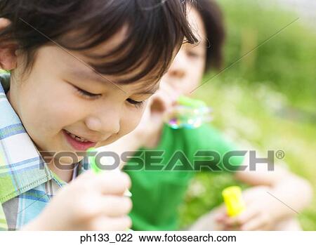 Children blowing bubbles View Large Photo Image Stock Image - Children blowing bubbles. Fotosearch