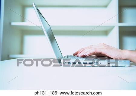 Stock Photograph - Pair of hands working on a laptop. Fotosearch