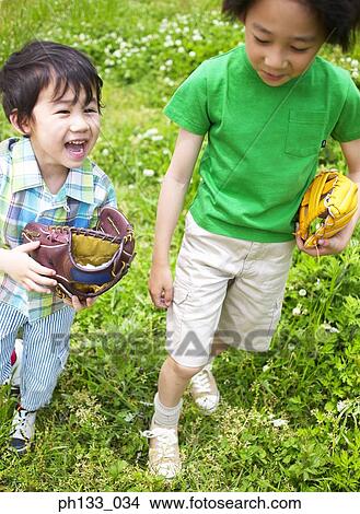 Two young boys smiling and walking with baseball mitts View Large Photo Image Picture - Two young boys smiling and walking with baseball mitts. Fotosearch