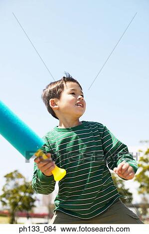 Young boy holding a softball bat View Large Photo Image Picture - Young boy holding a softball bat. Fotosearch