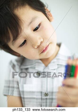 Stock Image - Young boy holding color pencils. Fotosearch