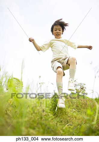 Picture - Young boy jumping. Fotosearch