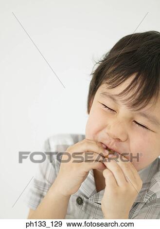 Young boy nibbling on something View Large Photo Image Stock Photo - Young boy nibbling on something. Fotosearch