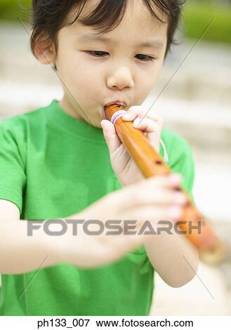 Young boy playing flute View Large Photo Image Stock Photo - Young boy playing flute. Fotosearch