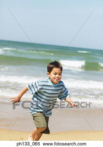 Young boy playing & running on beach View Large Photo Image Stock Photography - Young boy playing & running on beach. Fotosearch
