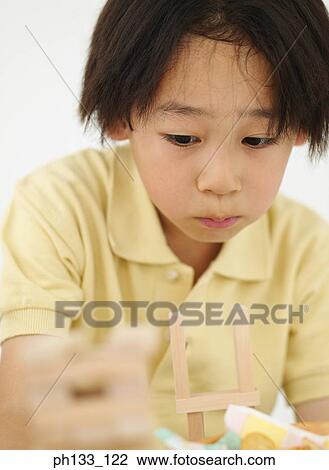 Young boy playing with wooden building blocks View Large Photo Image Stock Image - Young boy playing with wooden building blocks. Fotosearch