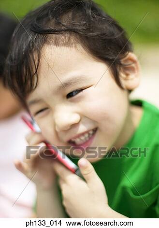 Young boy talking on mobile phone & smiling View Large Photo Image Picture - Young boy talking on mobile phone & smiling. Fotosearch