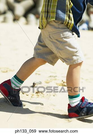 Young boy walking on beach View Large Photo Image Stock Photo - Young boy walking on beach. Fotosearch