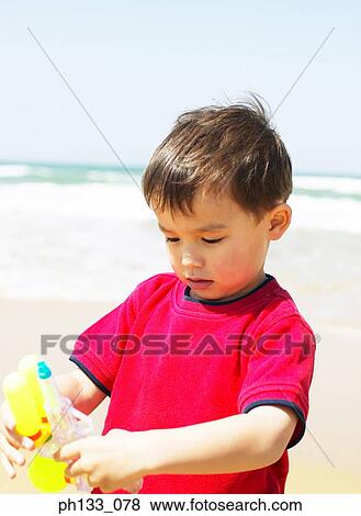 Young boy with water gun on beach View Large Photo Image Stock Photo - Young boy with water gun on beach. Fotosearch