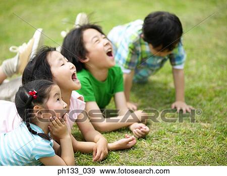 Young children lying down and looking up with mouths open View Large Photo Image Stock Photo - Young children lying down and looking up with mouths open. Fotosearch