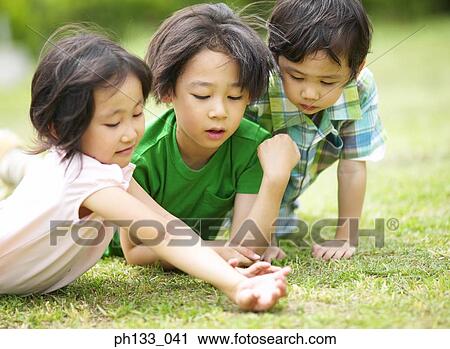 Young Children lying on lawn View Large Photo Image Stock Image - Young Children lying on lawn. Fotosearch