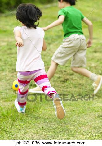 Young children playing football View Large Photo Image Stock Photograph - Young children playing football. Fotosearch