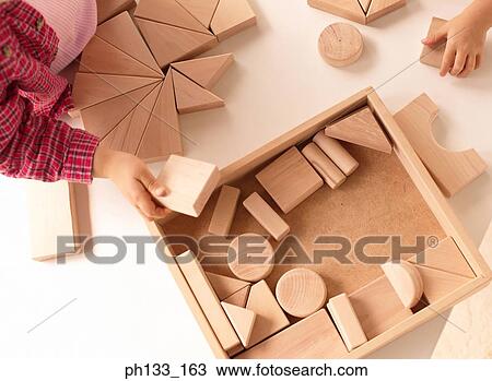 Young children playing with wooden shapes View Large Photo Image Stock Image - Young children playing with wooden shapes. Fotosearch