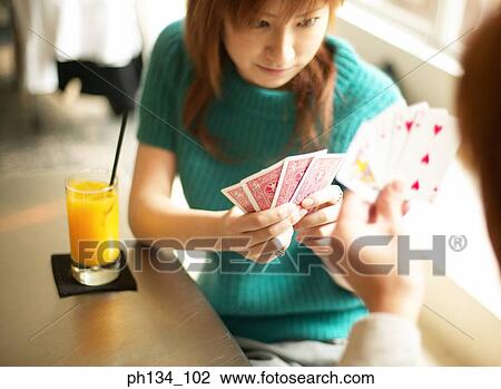 Stock Image - Young couple playing cards. Fotosearch