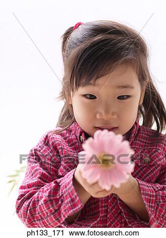 Stock Image - Young girl holding flower. Fotosearch