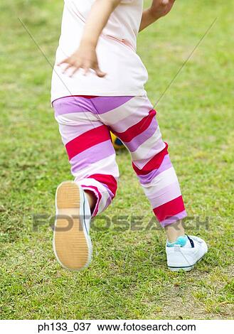 Young girl playing on a field View Large Photo Image Stock Photo - Young girl playing on a field. Fotosearch
