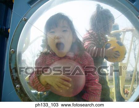 Stock Image - young girl shouting from behind a transparent plastic bubble. Fotosearch