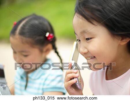 Young girl talking on mobile phone View Large Photo Image Stock Photography - Young girl talking on mobile phone. Fotosearch