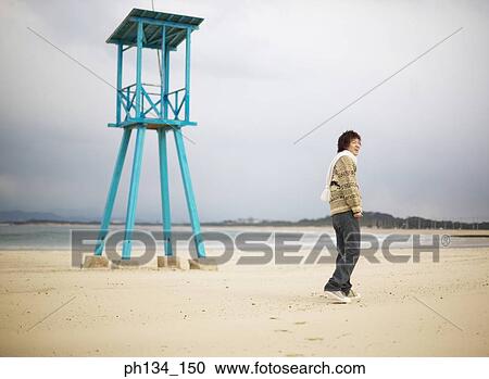 Stock Image - Young man at beach. Fotosearch