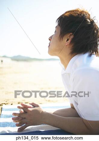 Stock Photography - Young man at beach. Fotosearch