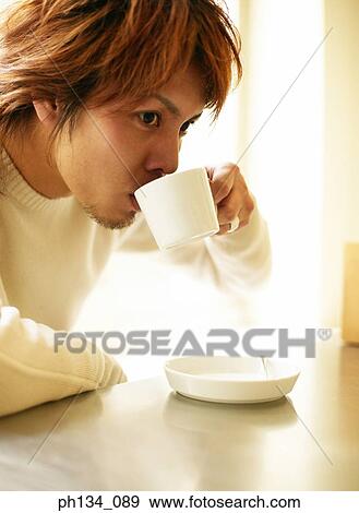 Young man drinking coffee View Large Photo Image Stock Photo - Young man drinking coffee. Fotosearch