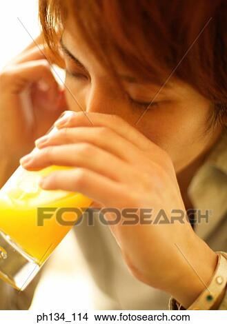 Picture - Young man drinking orange juice. Fotosearch