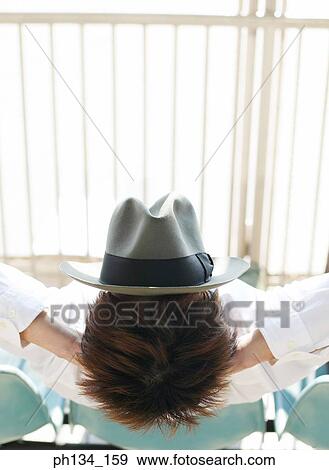 Young man resting with hat on face View Large Photo Image Stock Photo - Young man resting with hat on face. Fotosearch