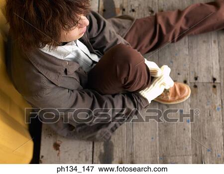 Young man sitting alone View Large Photo Image Stock Photo - Young man sitting alone. Fotosearch