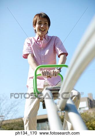Young man sitting on seesaw View Large Photo Image Stock Image - Young man sitting on seesaw. Fotosearch
