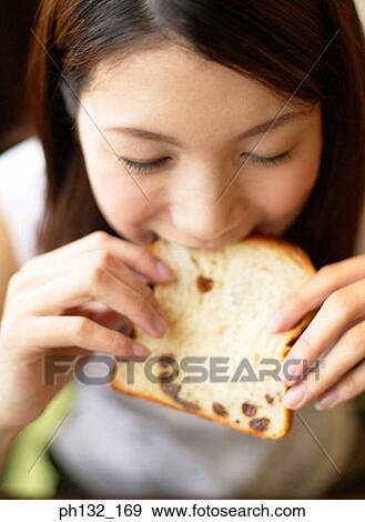 Young woman biting into a slice of bread View Large Photo Image Stock Photo - Young woman biting into a slice of bread. Fotosearch
