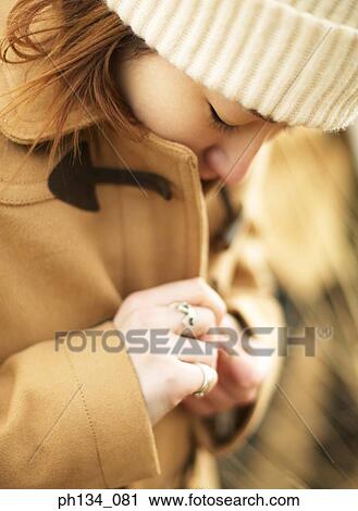 Young woman buttoning her coat View Large Photo Image Stock Image - Young woman buttoning her coat. Fotosearch