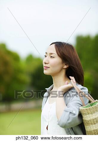 Stock Image - Young woman carrying a bag. Fotosearch