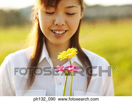 Young woman holding flowers View Large Photo Image Stock Image - Young woman holding flowers. Fotosearch