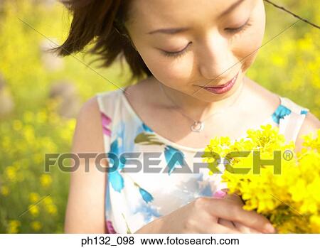 Stock Photo - Young woman holding flowers. Fotosearch