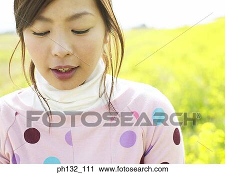 Stock Image - Young woman in a meadow. Fotosearch