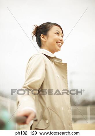Young woman leaning on a handrail and smiling View Large Photo Image Stock Photo - Young woman leaning on a handrail and smiling. Fotosearch