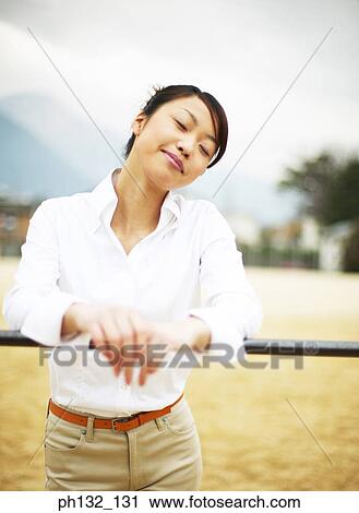 Young woman leaning on handrail View Large Photo Image Stock Image - Young woman leaning on handrail. Fotosearch