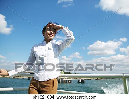 Picture - Young woman on a boat looking around. Fotosearch