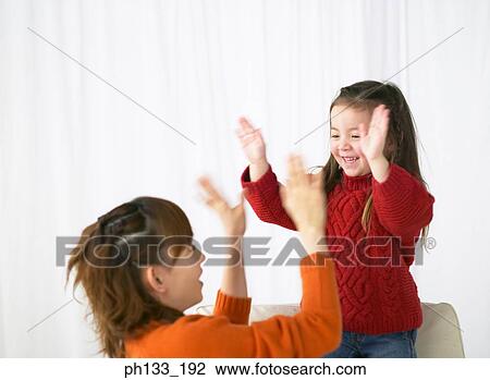 Young woman playing with daughter View Large Photo Image Stock Image - Young woman playing with daughter. Fotosearch