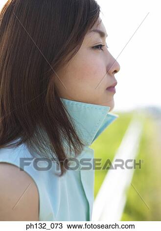 Young woman sitting and gazing ahead View Large Photo Image Stock Image - Young woman sitting and gazing ahead. Fotosearch