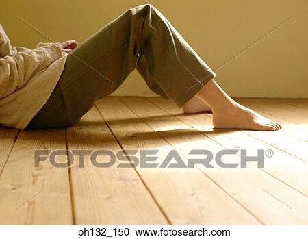 Stock Image - Young woman sitting on floor. Fotosearch