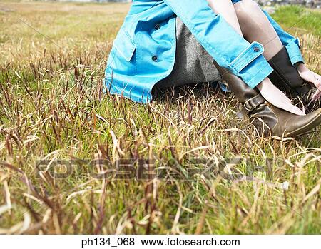 Young woman sitting on grass View Large Photo Image Stock Photo - Young woman sitting on grass. Fotosearch