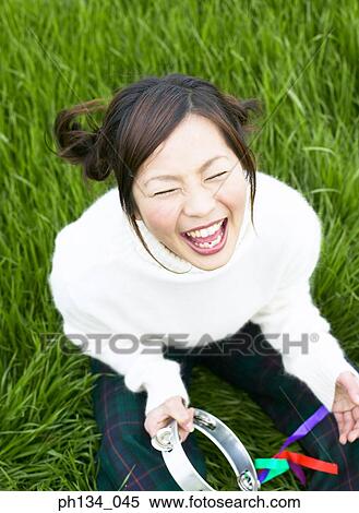 Young woman sitting playing music View Large Photo Image Stock Photography - Young woman sitting playing music. Fotosearch