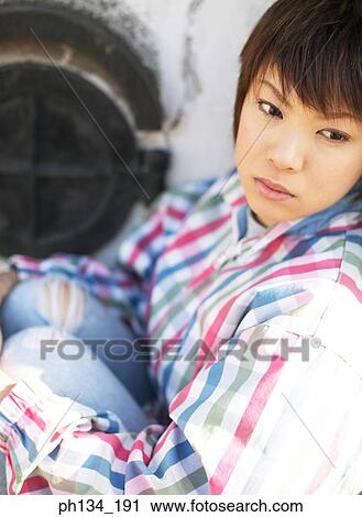 Young woman sitting with legs folded View Large Photo Image Stock Image - Young woman sitting with legs folded. Fotosearch