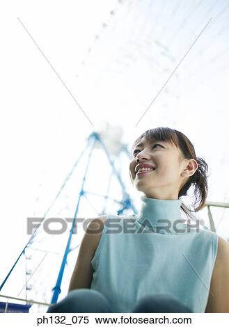 Young woman smiling at a carnival View Large Photo Image Stock Photography - Young woman smiling at a carnival. Fotosearch